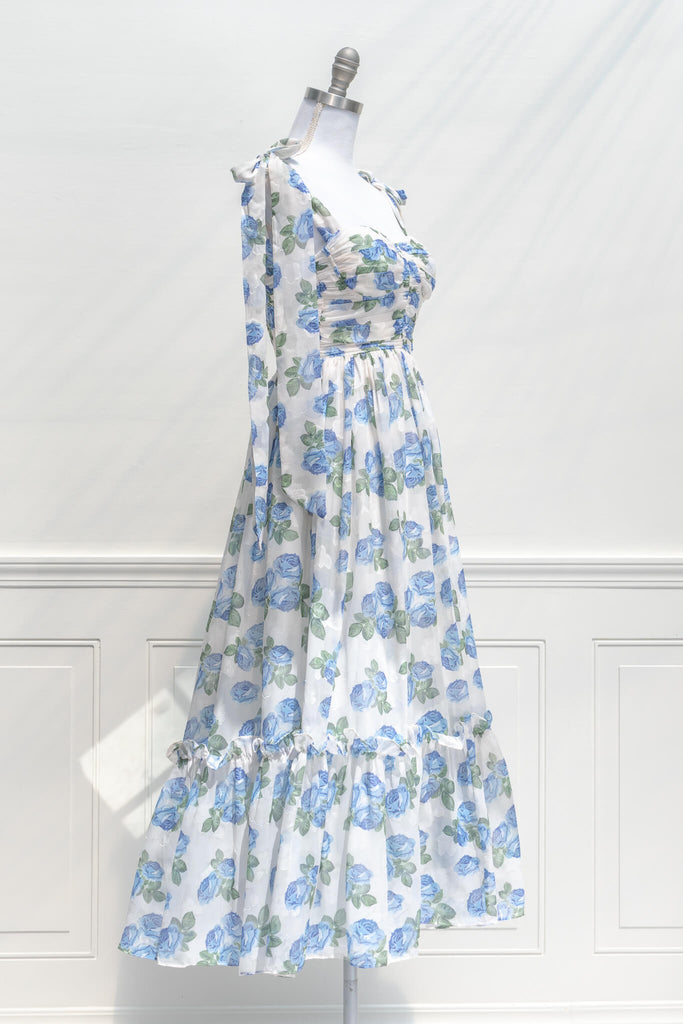 feminine clothing, french girl style - a long dress in blue rose print on white background with tie straps and sweetheart neckline - quarter view 