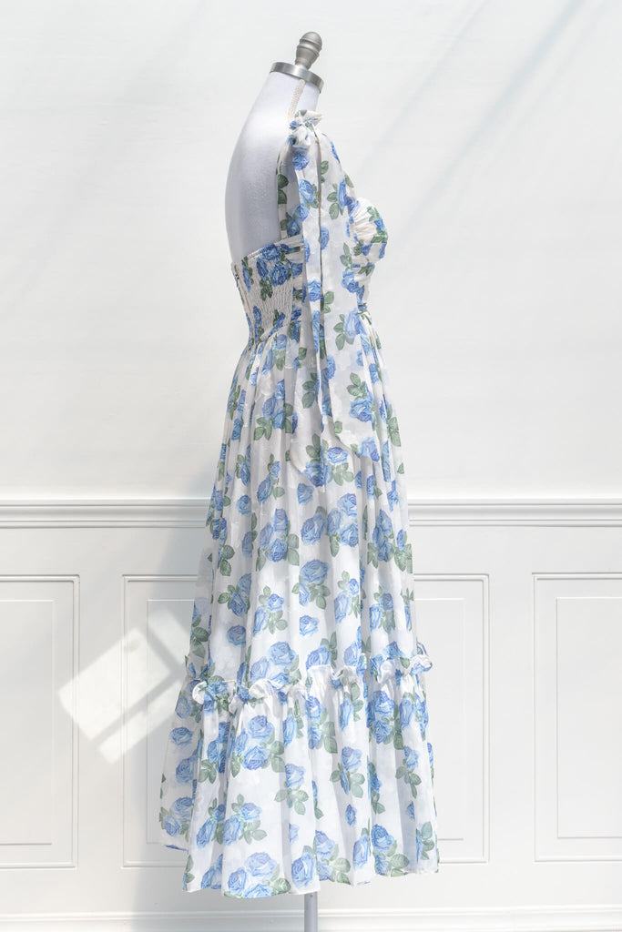 feminine clothing, french girl style - a long dress in blue rose print on white background with tie straps and sweetheart neckline - side view 