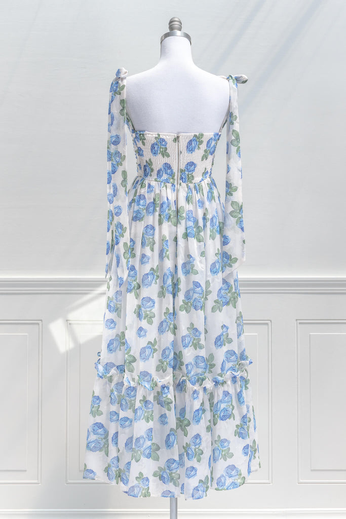 feminine clothing, french girl style - a long dress in blue rose print on white background with tie straps and sweetheart neckline - back view 