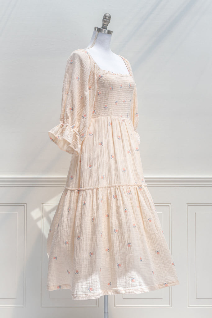 french dress - a feminine aesthetic dress in cream, with long sleeves, ruched midriff, square neckline, ruffle sleeves, and small floral print. Cream color base. Amantine - quarter view