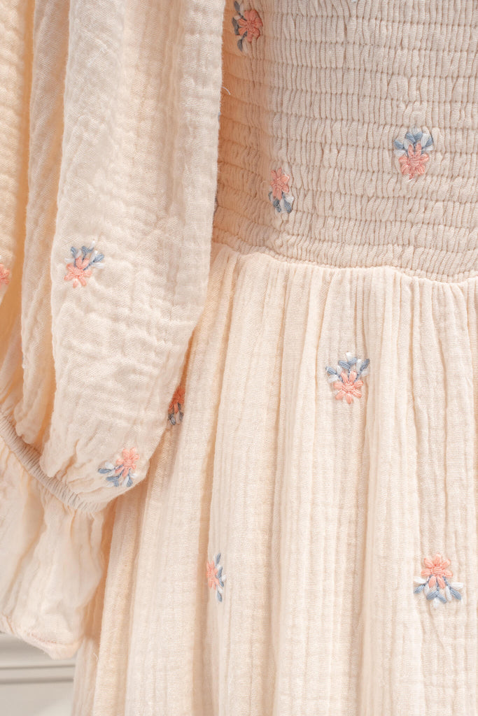 french dress - a feminine aesthetic dress in cream, with long sleeves, ruched midriff, square neckline, ruffle sleeves, and small floral print. Cream color base. Amantine - up close fabric view