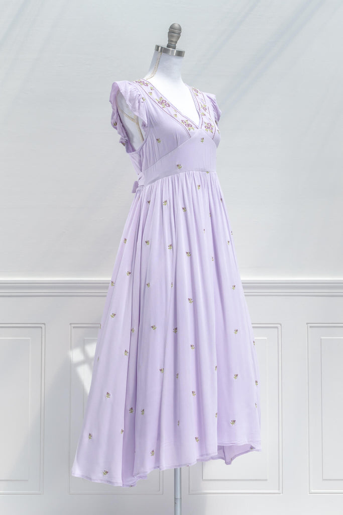 French Dress / A feminine floral embroidered dress with a v neckline and flutter sleeves in purple. quarter view
