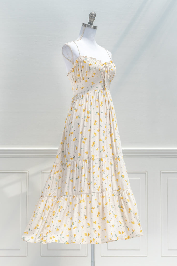 french dresses in vintage and cottage core style - a midi dress in cream and small flower print, drawstring neckline and spaghetti straps - quarter view 