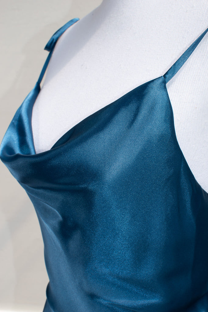 affordable formal gown for events. a long sapphire blue elegant formal dress with cowl neck and spaghetti straps. FRont view. Amantine. Detail of silky cowl neckline. 