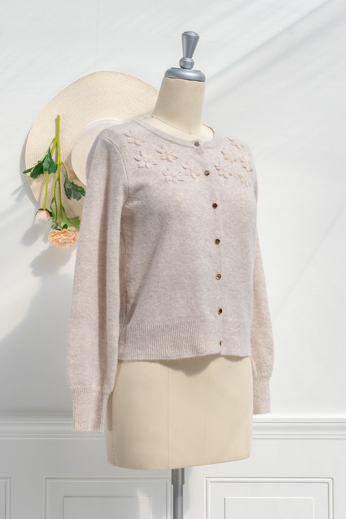 cute sweater in french and cottagecore style. features crew neck, long sleeves, pretty shiny buttons, and a relief flower embroidery above the bust. feminine cottagecore style top. front view. amantine.