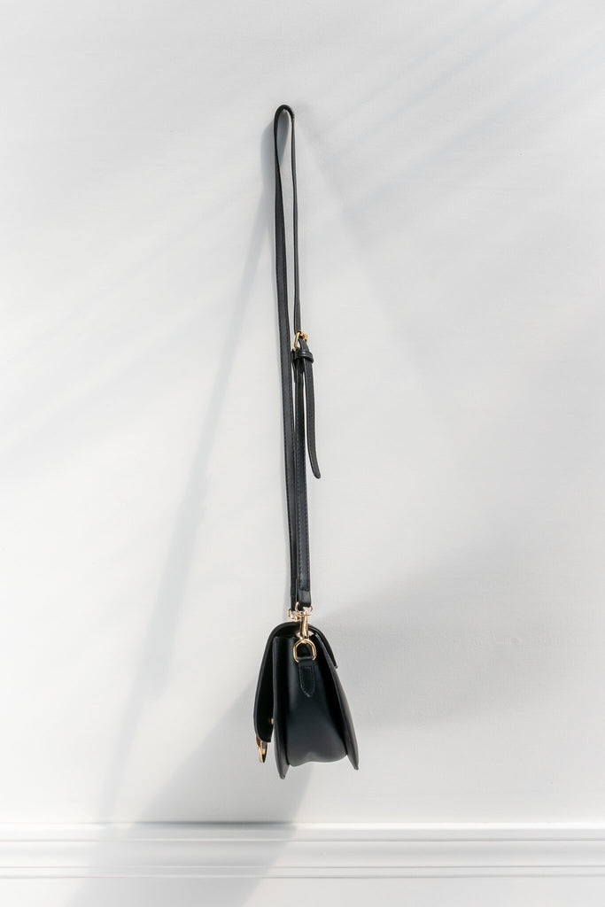 french style crossbody bag in black faux leather and gold buckle - side view 
