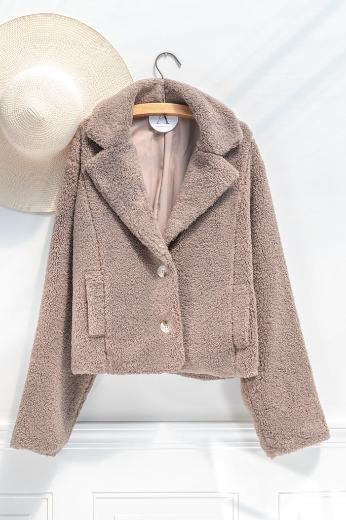 French feminine tops - a feminine winter sherpa coat in taupe - french and feminine outerwear - amantine - on clothes hanger view  