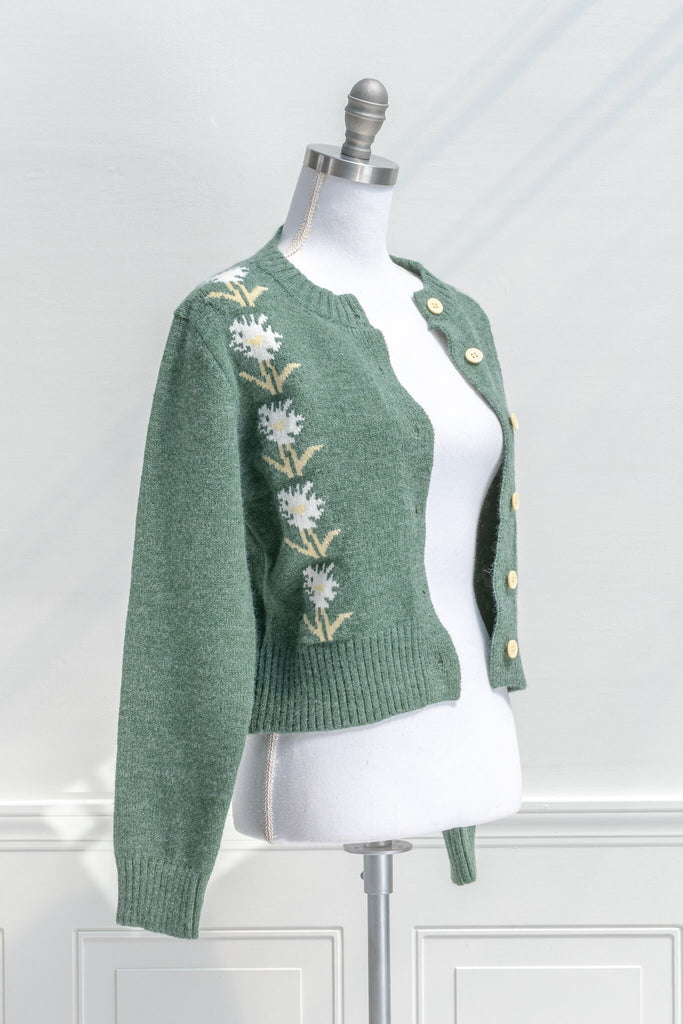 cottage core sweaters for autumn - a green wooly cardigan with floral motives cottagecore style- quarter view 