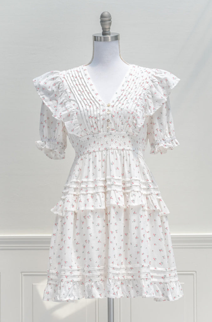 Parisian Parlour mini dress is the perfect addition to the dollette wardrobe. Featuring a lovely and delicate pink floral print on white cotton, short sleeves, a smocked elastic waistline, and pintuck-detailed skirt. aesthetic clothes - amantine - front view 