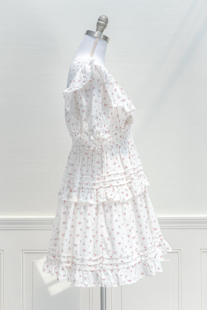 Parisian Parlour mini dress is the perfect addition to the dollette wardrobe. Featuring a lovely and delicate pink floral print on white cotton, short sleeves, a smocked elastic waistline, and pintuck-detailed skirt. aesthetic clothes - amantine - side view 