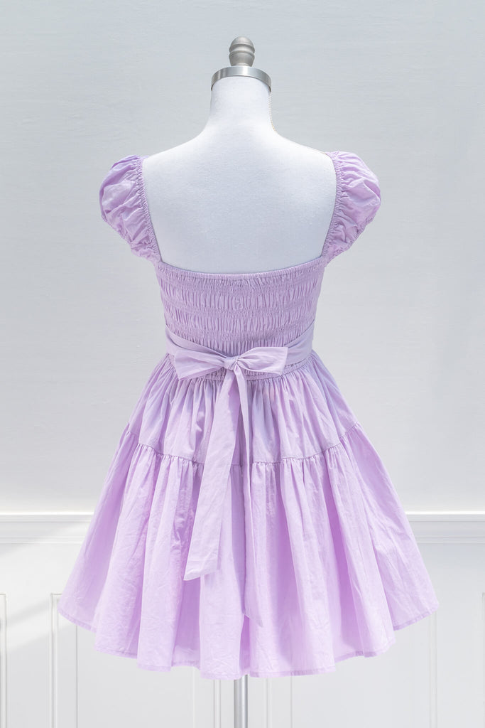 Sweet and feminine, the Lilac Meadows mini dress in lovely lavender cotton features a square neckline, short capped sleeves, fit-and-flare silhouette, and a smocked elastic bodice with side ties. back View