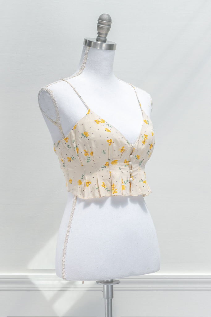 aesthetic clothes -A lovely little top of a breezy summer aesthetic, the camisole features a delicate yellow floral print, a cropped length, button-front closure, and an open, corset-style back. Front View 