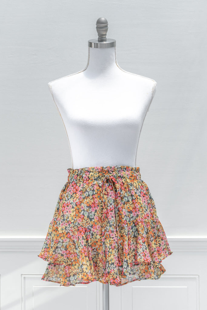 A feminine French inspired skirt:A pop of color for summertime, the fun and flirty BLANK mini skort features an elastic waistline, yellow and pink floral print chiffon, and a tiered outer skirt with a skort-style inner lining - aesthetic clothes - amantine - front view