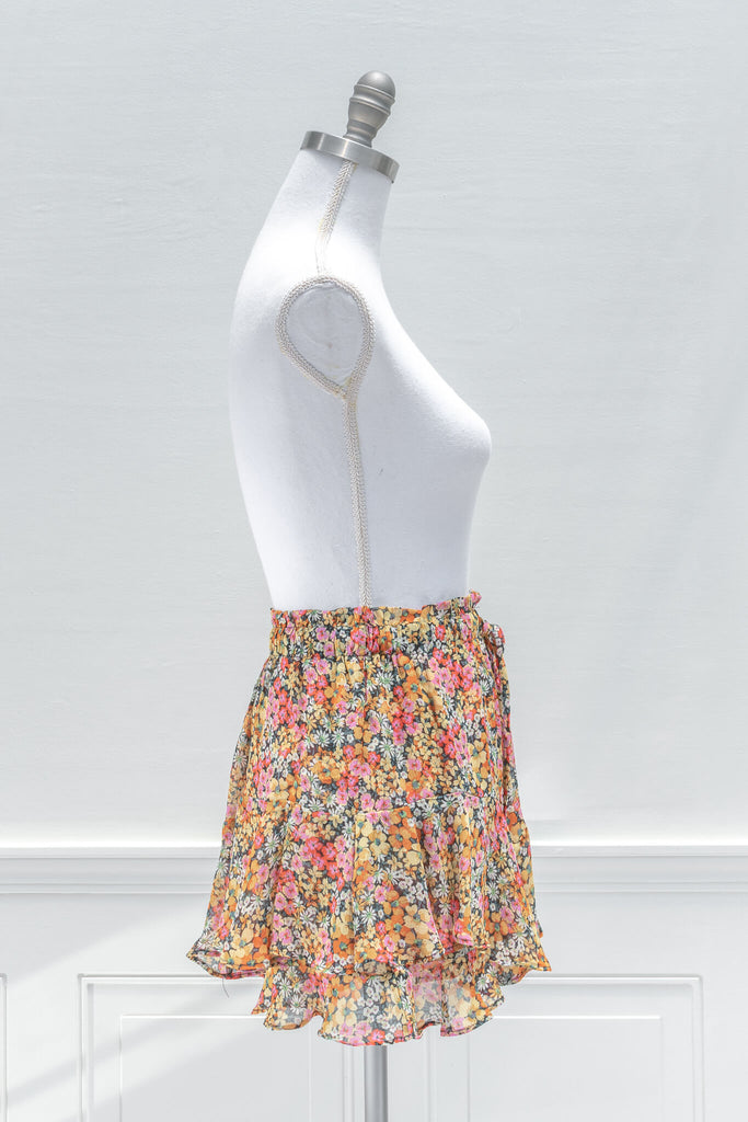 A feminine French inspired skirt:A pop of color for summertime, the fun and flirty BLANK mini skort features an elastic waistline, yellow and pink floral print chiffon, and a tiered outer skirt with a skort-style inner lining - aesthetic clothes - amantine - side view