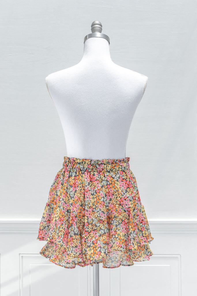 A feminine French inspired skirt:A pop of color for summertime, the fun and flirty BLANK mini skort features an elastic waistline, yellow and pink floral print chiffon, and a tiered outer skirt with a skort-style inner lining - aesthetic clothes - amantine - back view
