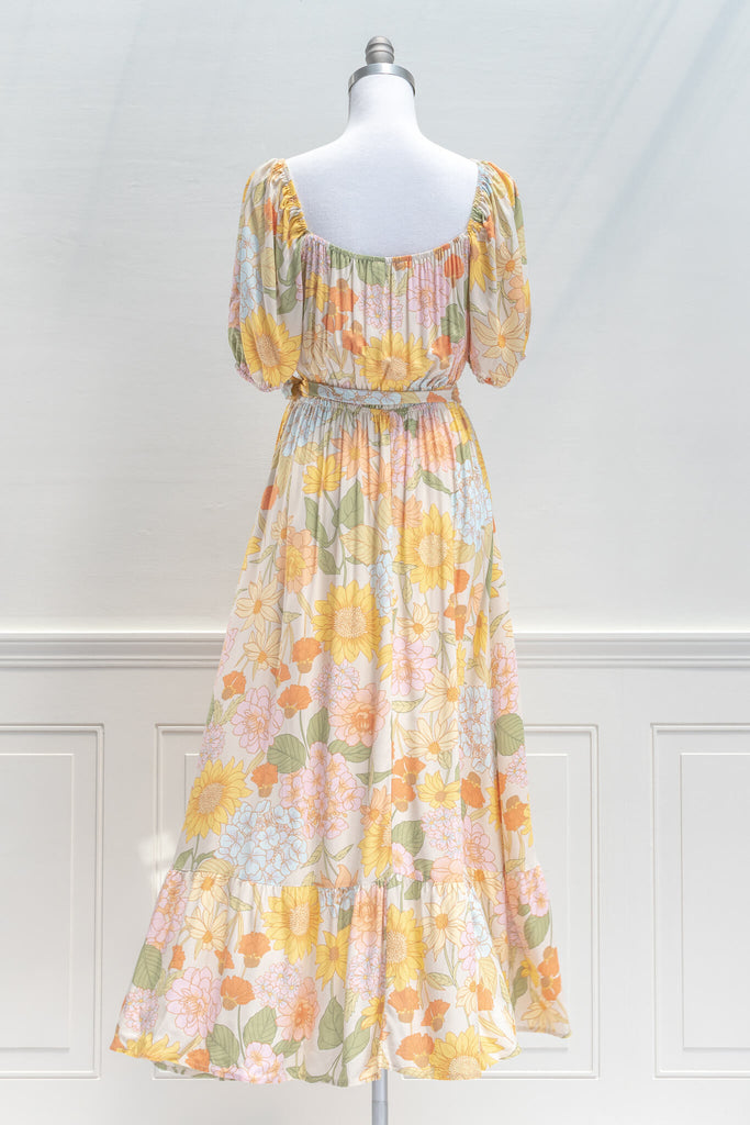 French Dresses - a Maxi in yellow and green florals features a faux-wrap v-neckline, a removable waist tie, shorts sleeves, and elastic waistline for a comfortable fit. Amantine clothing - back view 