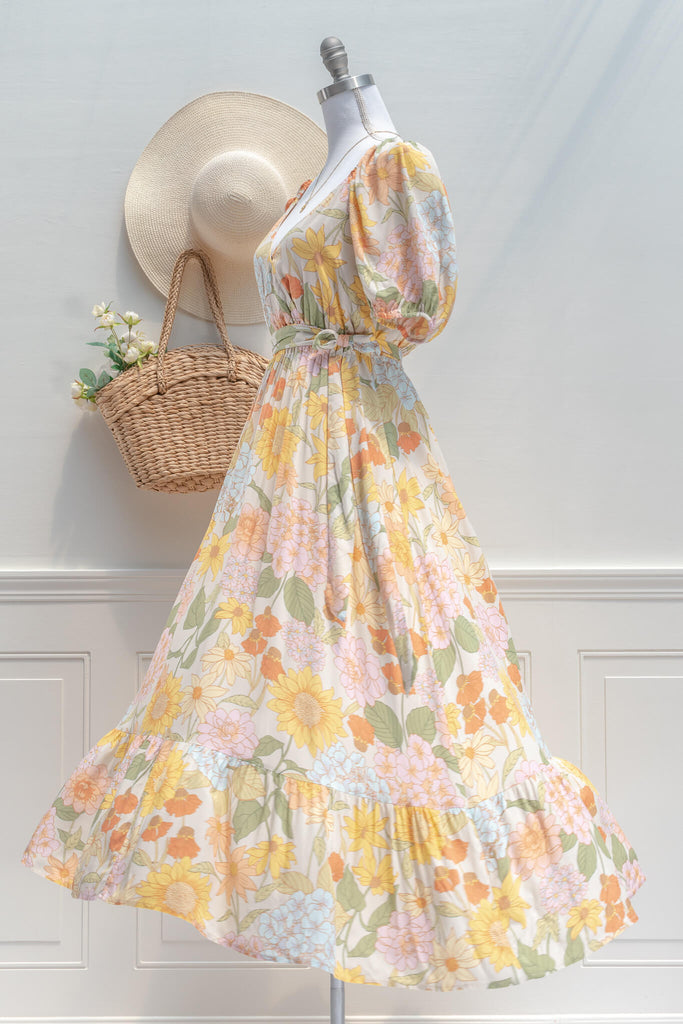 French Dresses - a Maxi in yellow and green florals features a faux-wrap v-neckline, a removable waist tie, shorts sleeves, and elastic waistline for a comfortable fit. Amantine clothing - Front view 