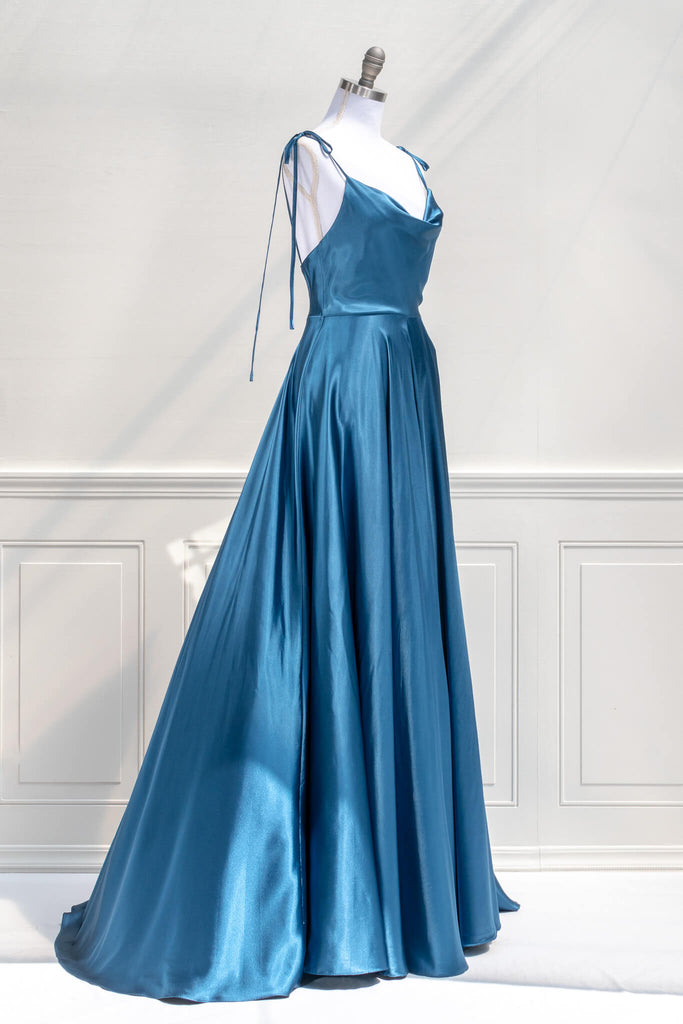 affordable formal gown for events. a long sapphire blue elegant formal dress with cowl neck and spaghetti straps. Side view. Amantine. 