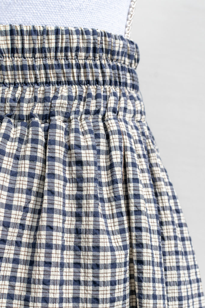 Close-up of elasticized waistband on the Arden plaid midi skirt