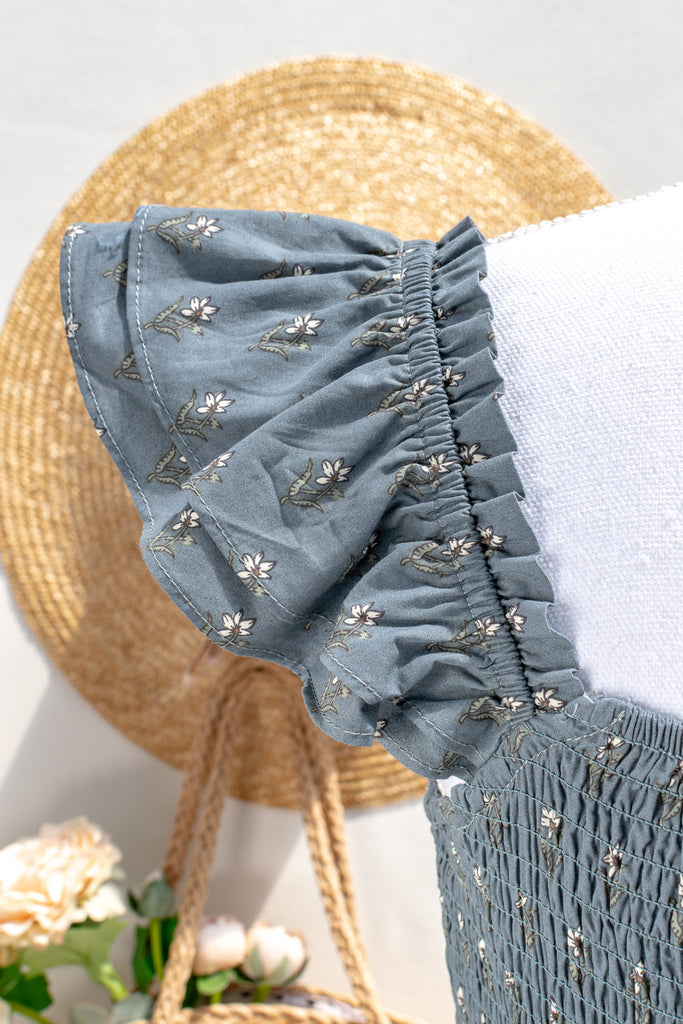 Close-up of ruffled shoulder on the Camille dusty blue floral dress