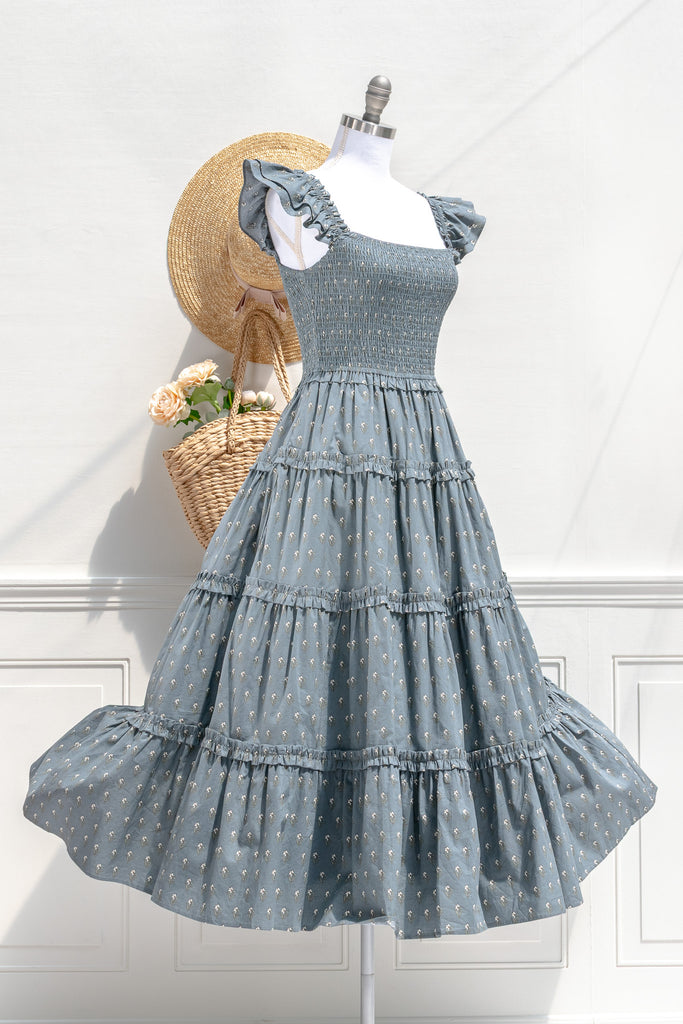 Camille dusty blue floral smocked midi dress — three-quarter view showing ruffled sleeves and tiered silhouette