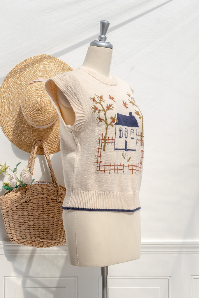 Homestead cream sweater vest—three-quarter view showing house motif and ribbed neckline