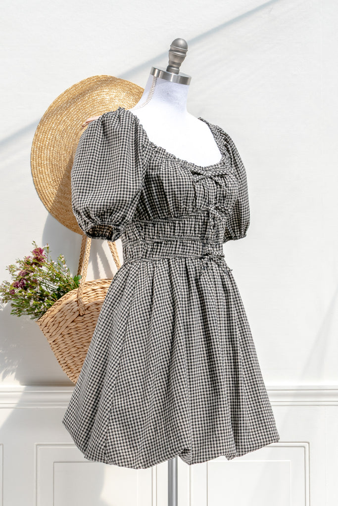 Lucie black-and-ivory gingham mini dress — three-quarter view showing double-shirred waist and bow details
