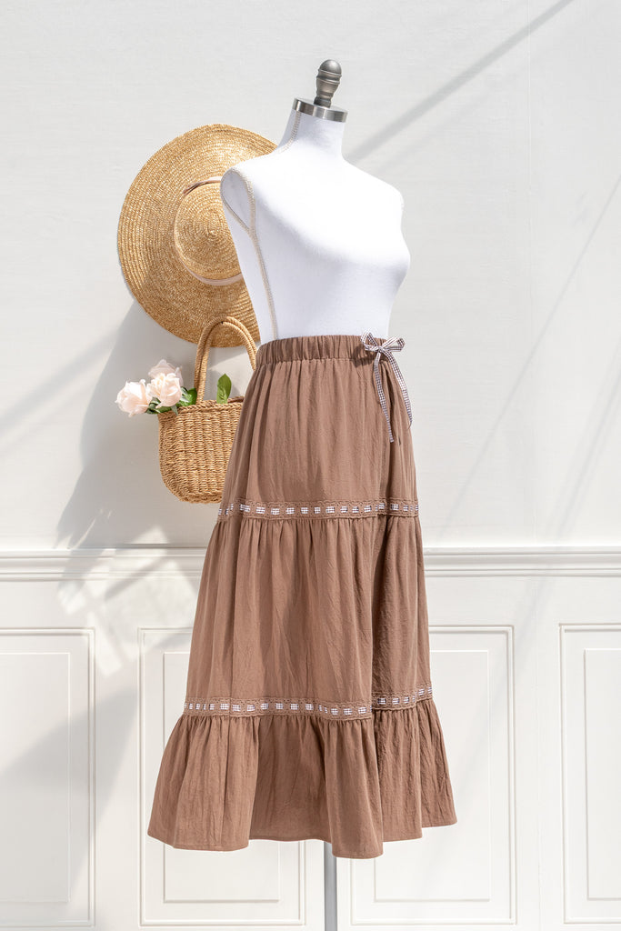 Luisa chestnut cotton midi skirt—three-quarter view showing tiered silhouette and gingham trim