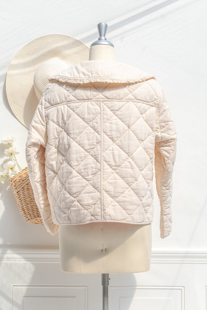 Mari cream quilted jacket — back view with diamond quilting and curved hem