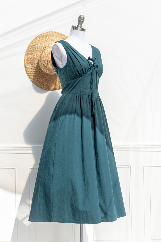 Nora turquoise green cotton midi dress — three-quarter view showing V-neck bodice and gathered waist