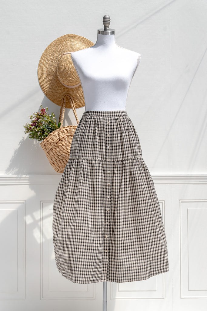 Amantine Schoolhouse plaid button-front midi skirt in black/ivory with side pockets and half-elastic waistband — front view