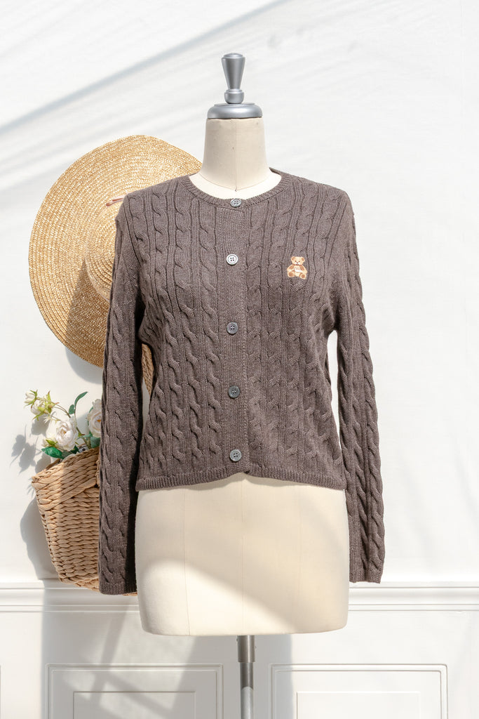Amantine Teddy cable-knit cardigan in cocoa with button front, cropped fit, and embroidered teddy bear patch — front view