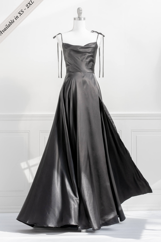 french elegant long black gown - made of a silky and shiny black fabric, with spaghetti straps, and a french feminine cowl neckline. features a side slit. front view - amantine.   