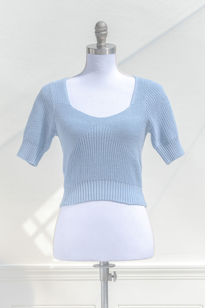 cottagecore outfits and feminine tops in french girl style. a blue knit top with short sleeves and low neckline. front view. amantine. 