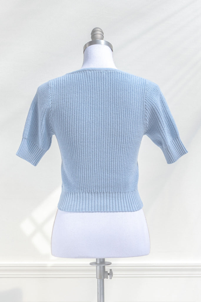 cottagecore outfits and feminine tops in french girl style. a blue knit top with short sleeves and low neckline. back view. amantine. 