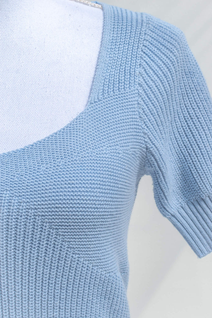 cottagecore outfits and feminine tops in french girl style. a blue knit top with short sleeves and low neckline. up close fabric view. amantine. 