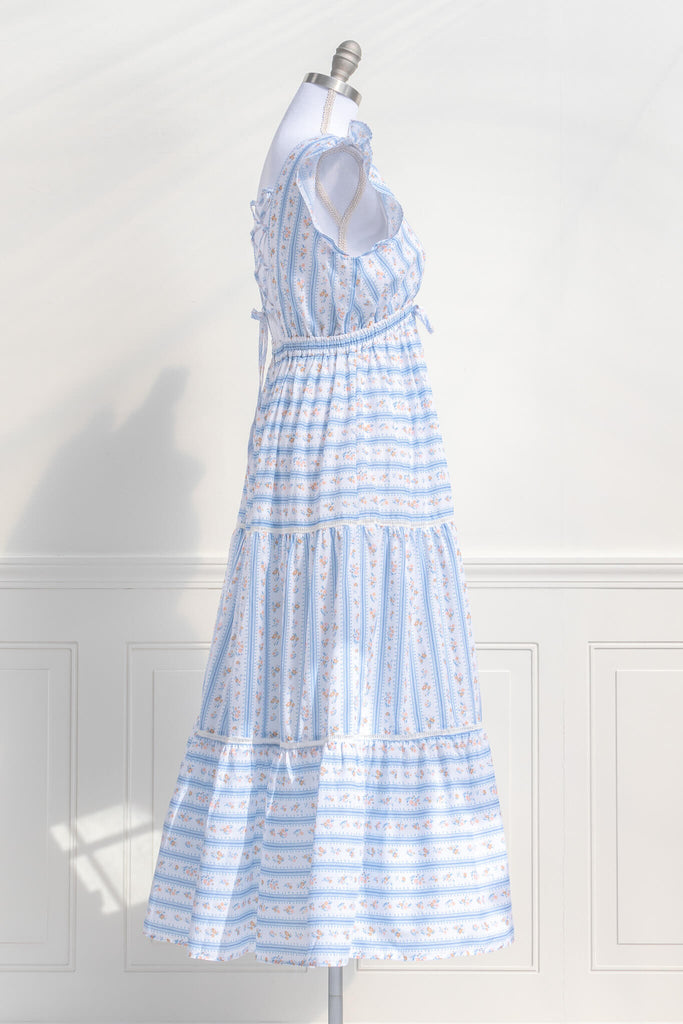 cottagecore dresses for spring. a french inspired dress with a v neck, ruffle sleeves, bow detail, and long skirt. made of a french country style print. second side view. amantine dresses.