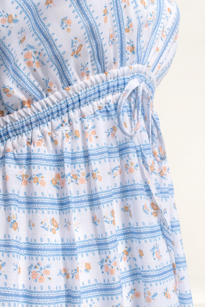 cottagecore dresses for spring. a french inspired dress with a v neck, ruffle sleeves, bow detail, and long skirt. made of a french country style print. up close fabric view showing ditsy floral print. amantine dresses.