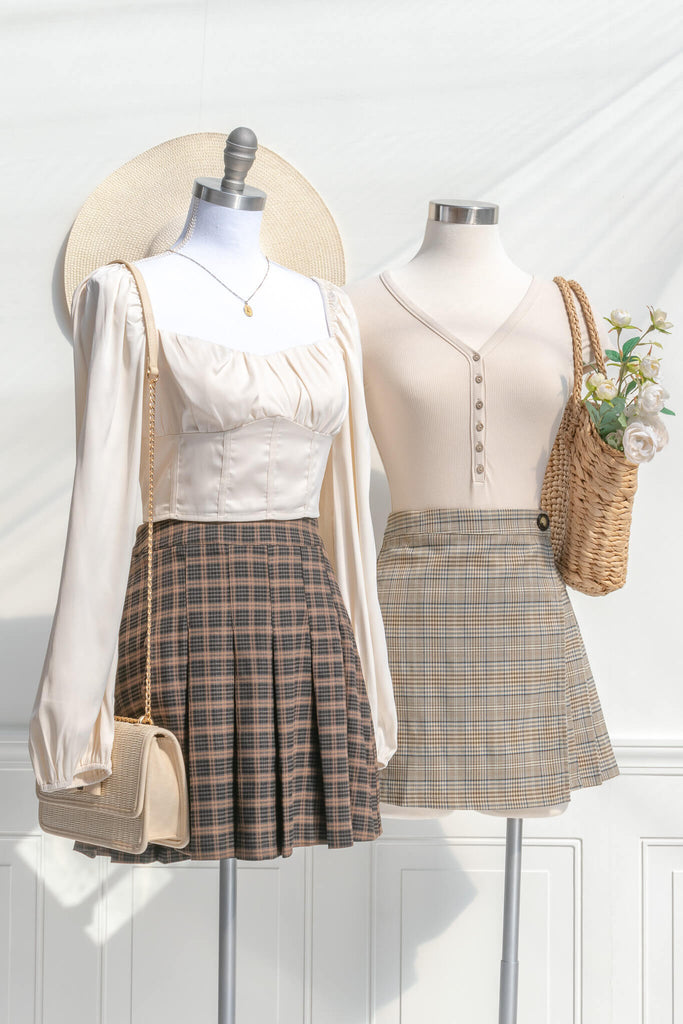two short skirt cottagecore style outfits. one short skirt is made of a plaid box pleat, the other a wrap style short skirt. amantine short skirts. 