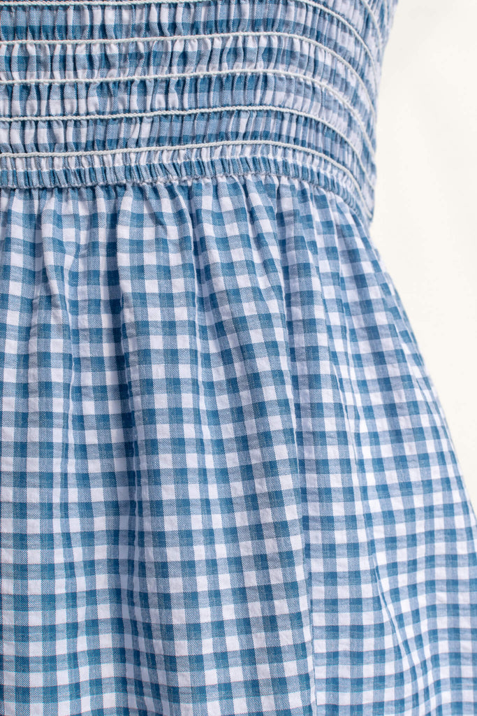 boutique dresses in a cottagecore outfit style. a blue and white gingham picnic dress with straps. fabric up close view. amantine. 