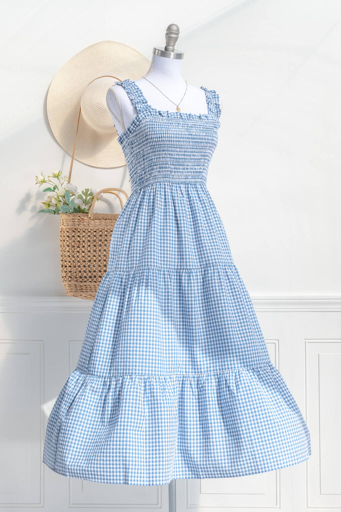boutique dresses in a cottagecore outfit style. a blue and white gingham picnic dress with straps. side view. amantine. 