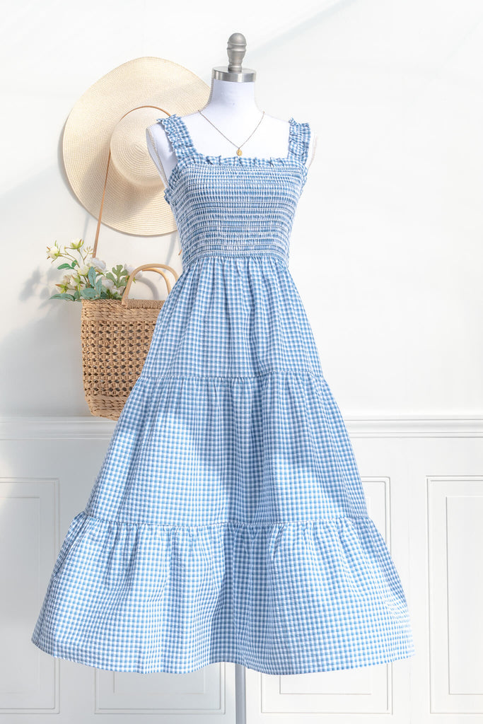 boutique dresses in a cottagecore outfit style. a blue and white gingham picnic dress with straps. front view. amantine. 