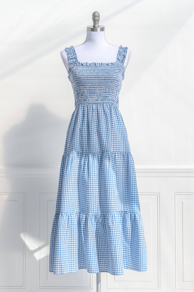 boutique dresses in a cottagecore outfit style. a blue and white gingham picnic dress with straps. front 2 view. amantine. 