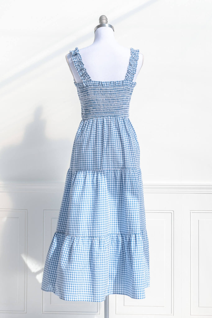 boutique dresses in a cottagecore outfit style. a blue and white gingham picnic dress with straps. back view. amantine. 