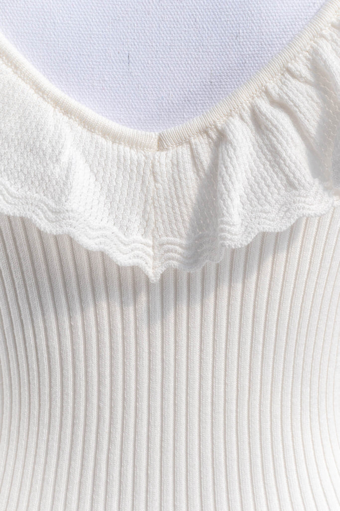 cottagecore outfits - a cottage core feminine top in french style. frilled neckline, sleeveless, and ribbed knit bodice in white. up close fabric view - amantine.