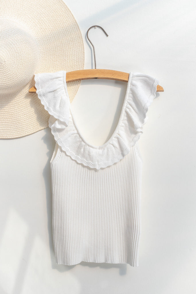 cottagecore outfits - a cottage core feminine top in french style. frilled neckline, sleeveless, and ribbed knit bodice in white. on hanger view - amantine.