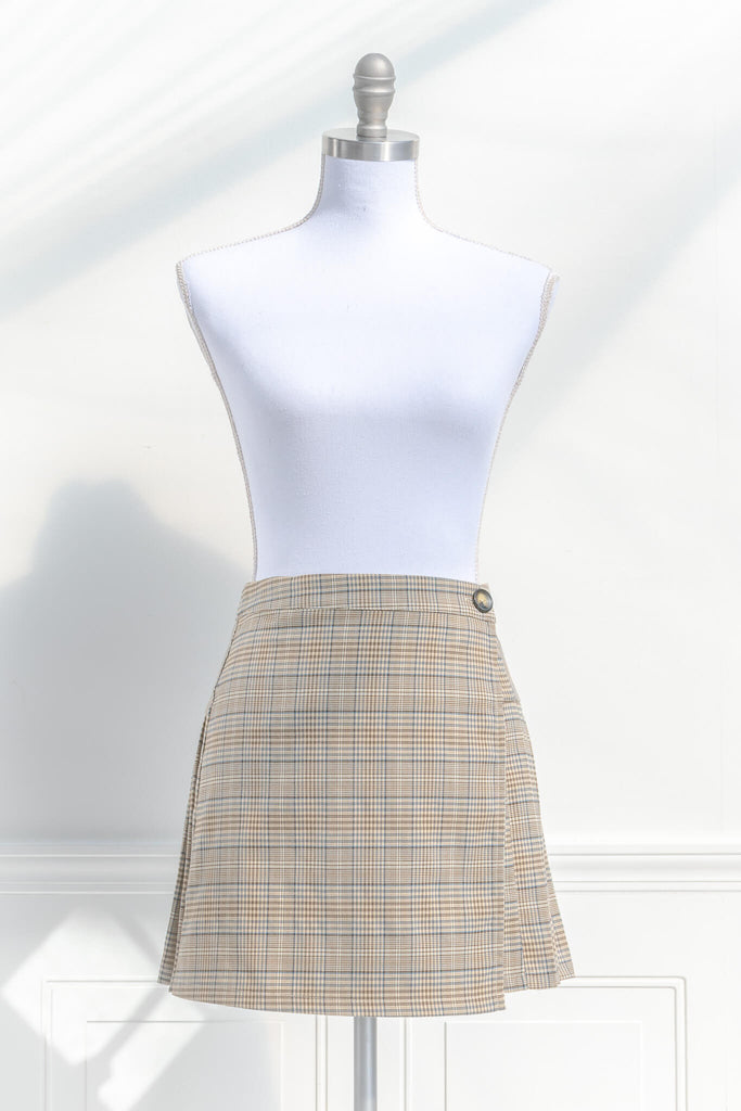 short skirts. a short skirt in light brown plaid. wrap around style. feminine short skirts. front view. amantine.
