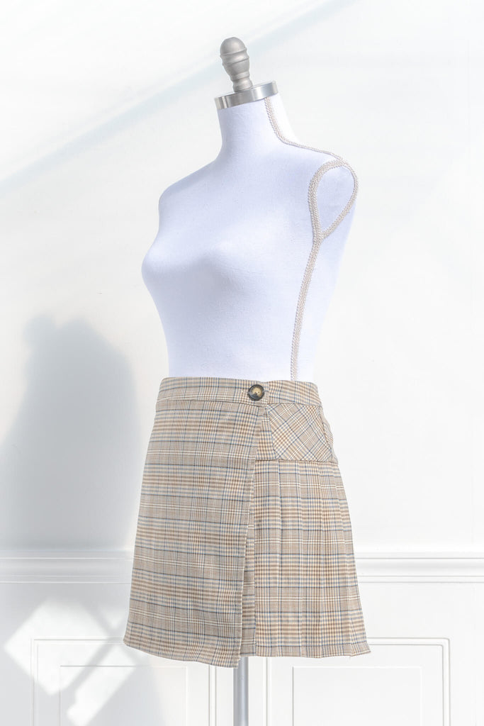 short skirts. a short skirt in light brown plaid. wrap around style. feminine short skirts. quarter side view. amantine.