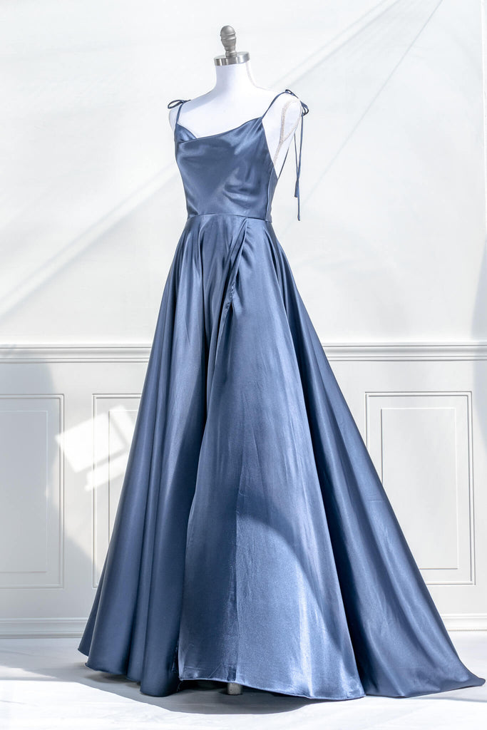 boutique dresses french style - a long blue satin prom dress, with a cowl neckline, spaghetti straps, and a stunning full sweeping gown skirt. quarter view. amantine.