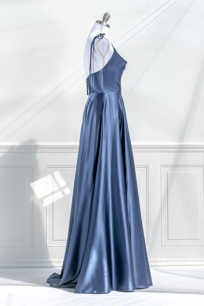 boutique dresses french style - a long blue satin prom dress, with a cowl neckline, spaghetti straps, and a stunning full sweeping gown skirt. side view. amantine.